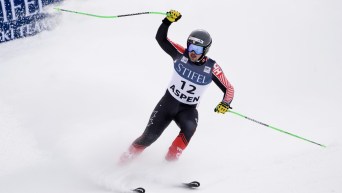 James Crawford lève le bras pour célébrer en bas de la piste.