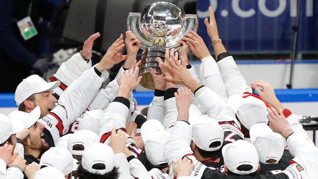 Des joueurs de hockey soulèvent un trophée.