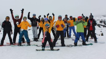 Liam Gill et un groupe de jeunes planchistes autochtones posent au sommet d'une montagne