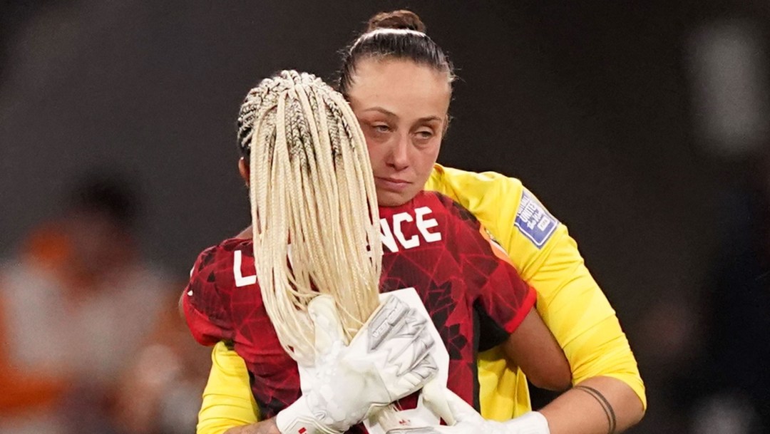 Deux joueuses de soccer se serrent dans les bras.