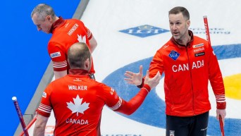 Brad Gushue célèbre en tapant dans la main de Geoff Walker.