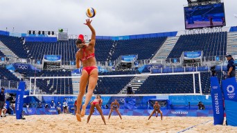 Wide shot of a serve being made in a beach volleyball game