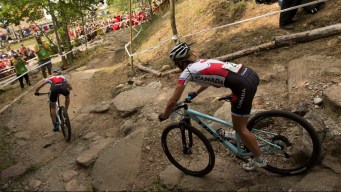 Two mountain bikers race on a downhill dirt trail