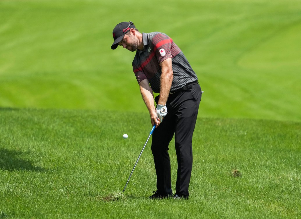 Corey Conners chips a golf ball from the fairway 