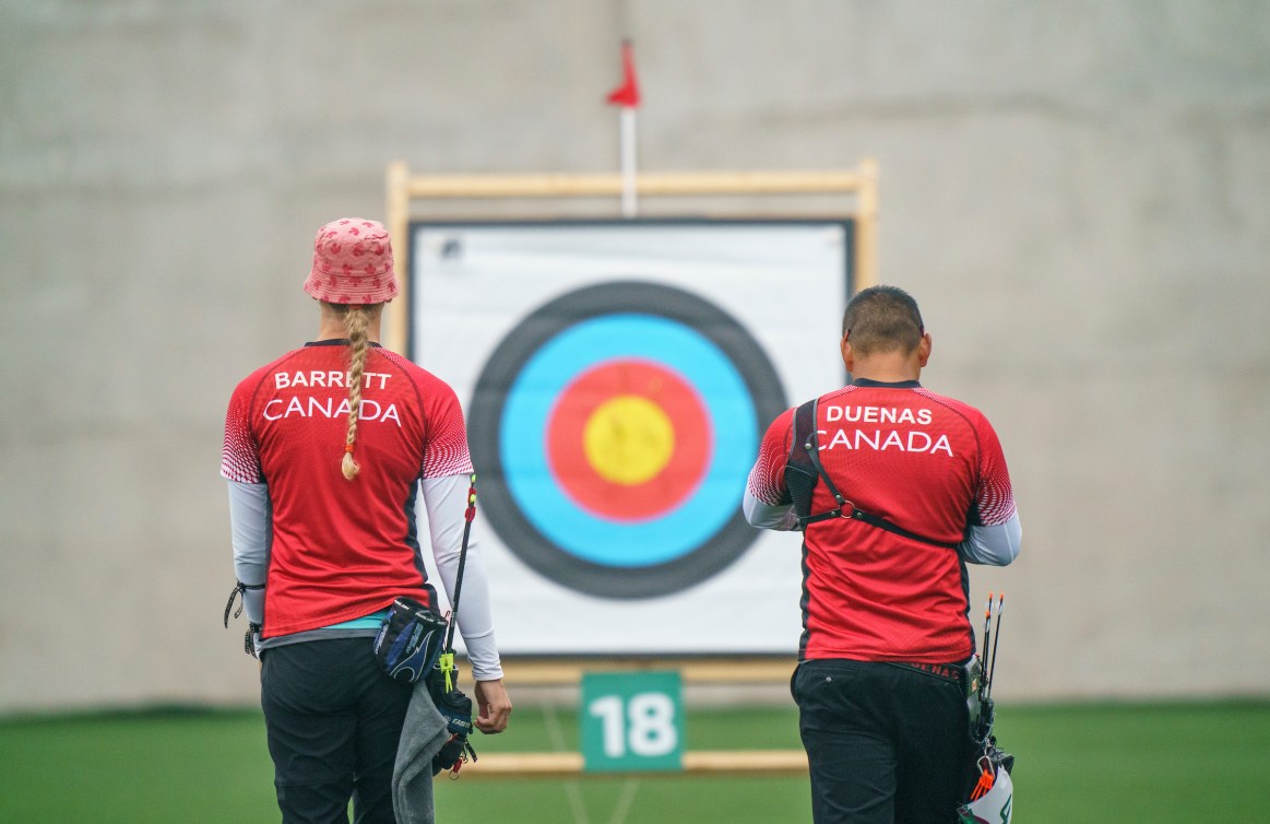 Crispine Duenas and Stephanie Barrett stand back on facing a target visible between them