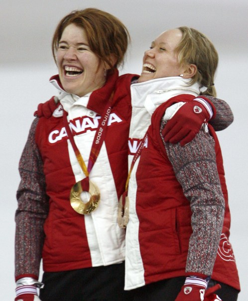 Clara Hughes and Cindy Klassen sing O Canada together after winning gold and bronze in the 5000m at Turin 2006.