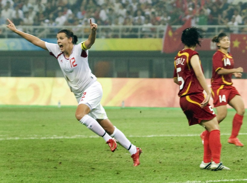 Canada's Christine Sinclair celebrates after scoring the team's first goal as China's Weng Xinzhi (5) and Liu Huana(14) look on during first half action in their first round soccer match at the Olympic Sport Stadium in Tianjin China Saturday, August 9, 2008. THE CANADIAN PRESS/Ryan Remiorz