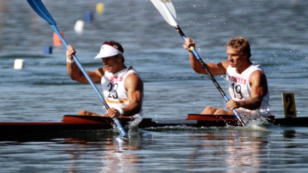 Alwyn Morri and Hugh Fisher paddling in the water.