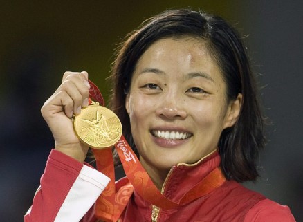 Canada's Carol Huynh from Hazelton, B.C. holds up her gold medal for the women's freestyle 48kg wrestling during victory ceremonies at the Beijing 2008 Summer Olympics in Beijing, Saturday, August 16, 2008. THE CANADIAN PRESS/Paul Chiasson