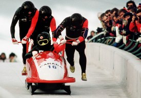 Four men running with bobsleigh