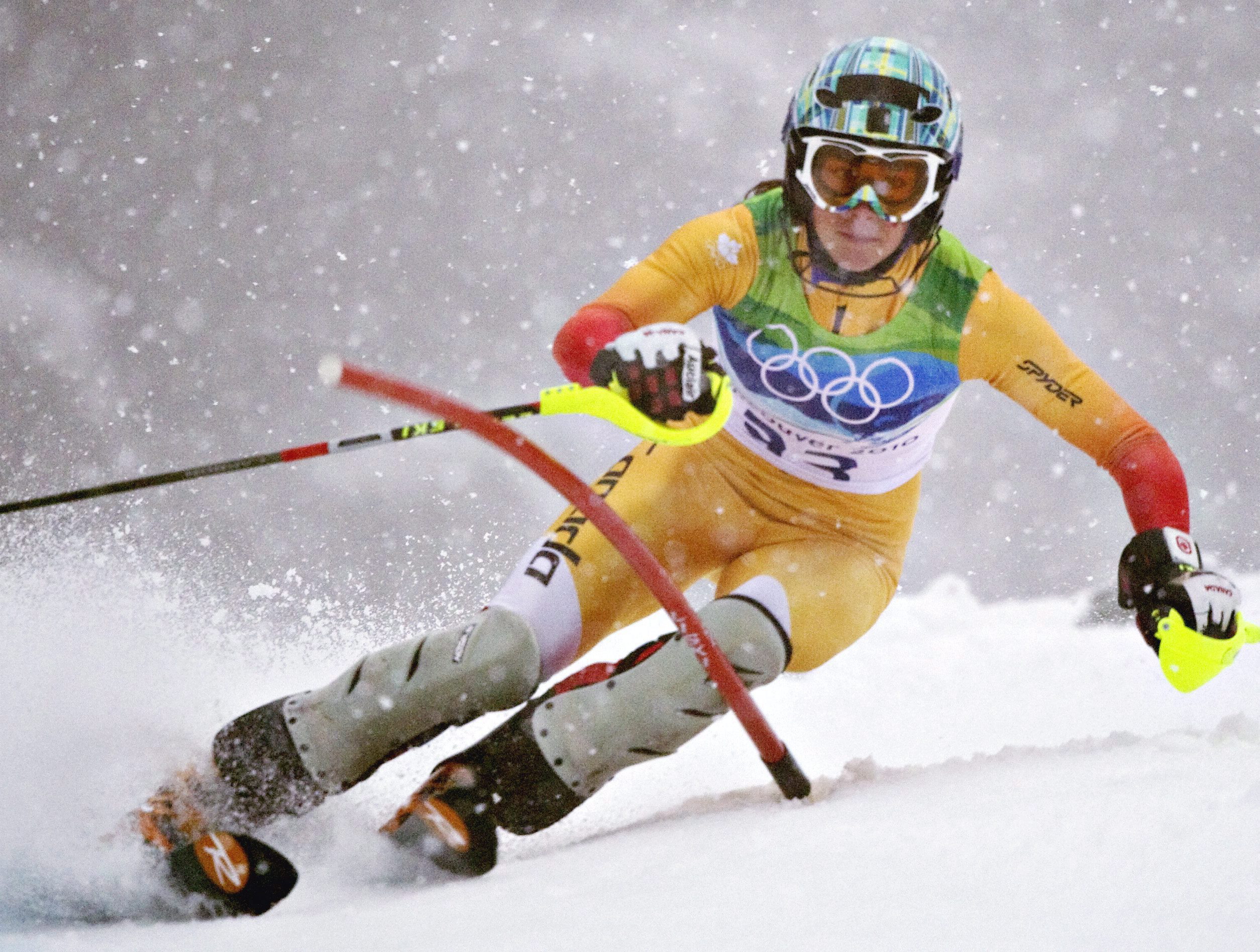 An alpine skier goes around a slalom gate