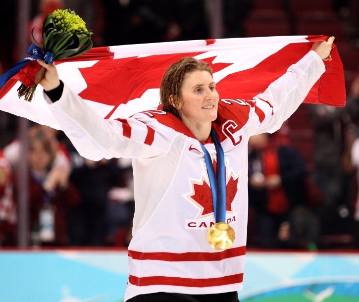 Wickenheiser on skates holding Canadian flag