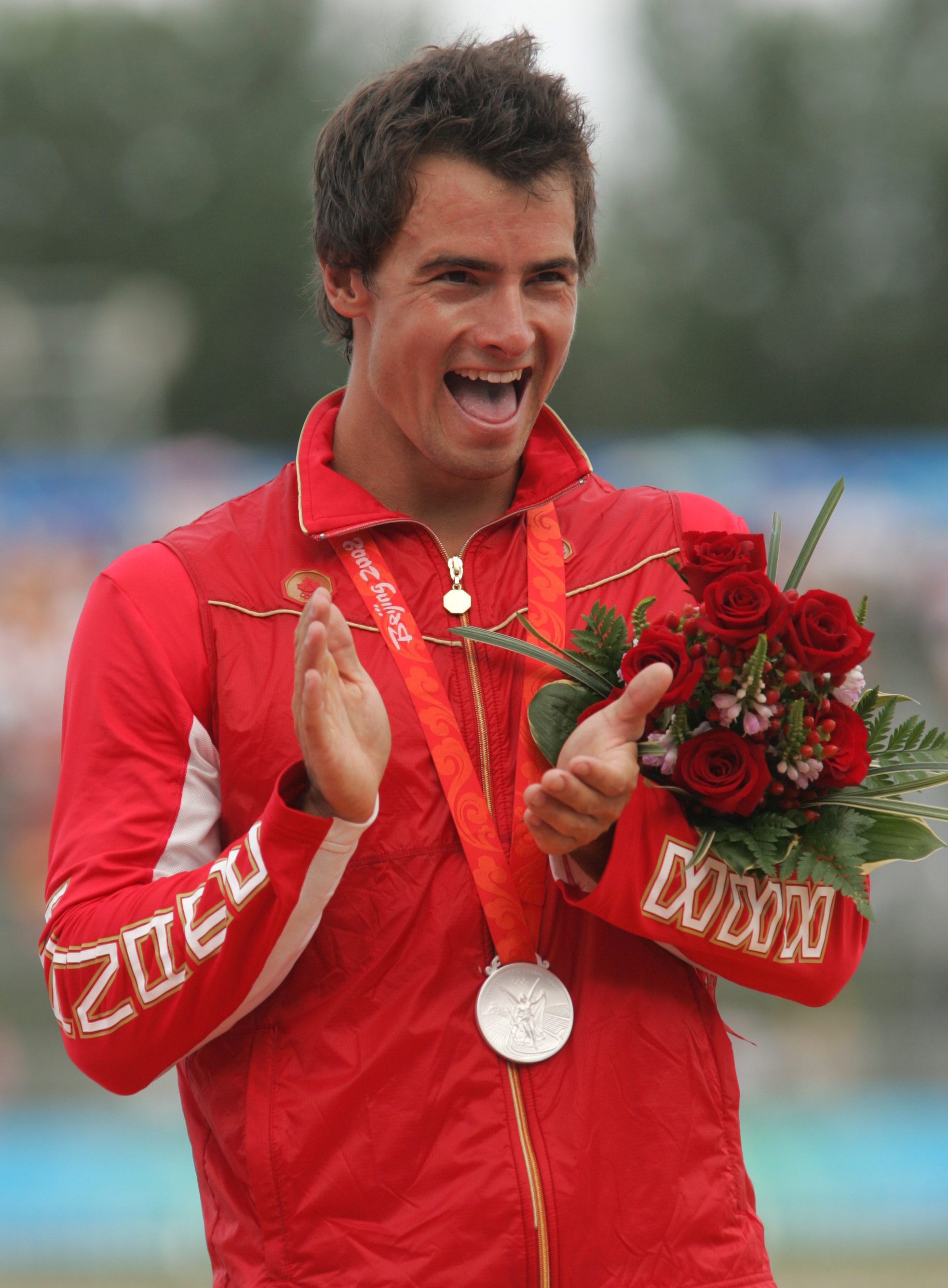 Adam van Koeverden claps on the podium