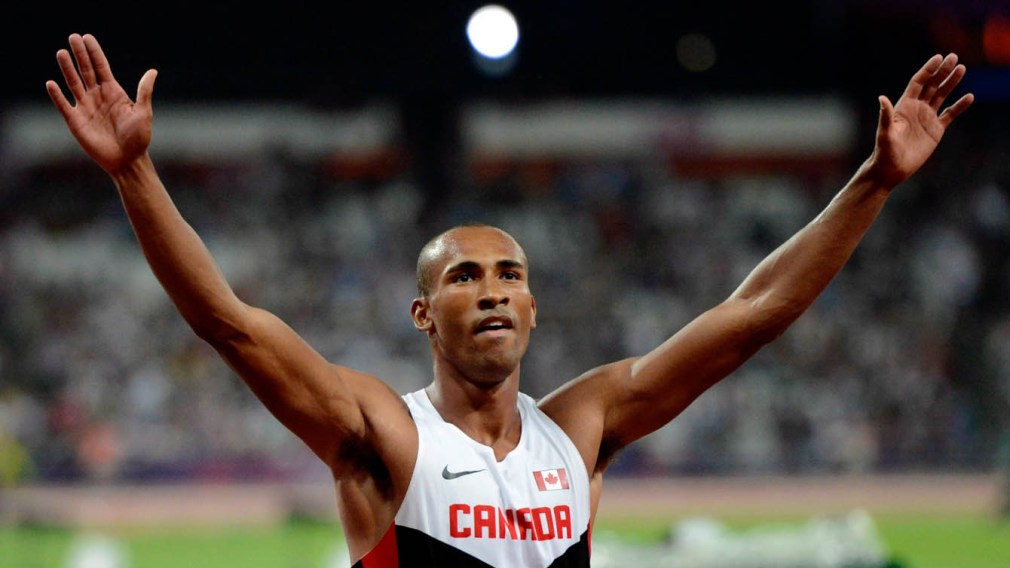 Damian Warner poses with both his hands in the air
