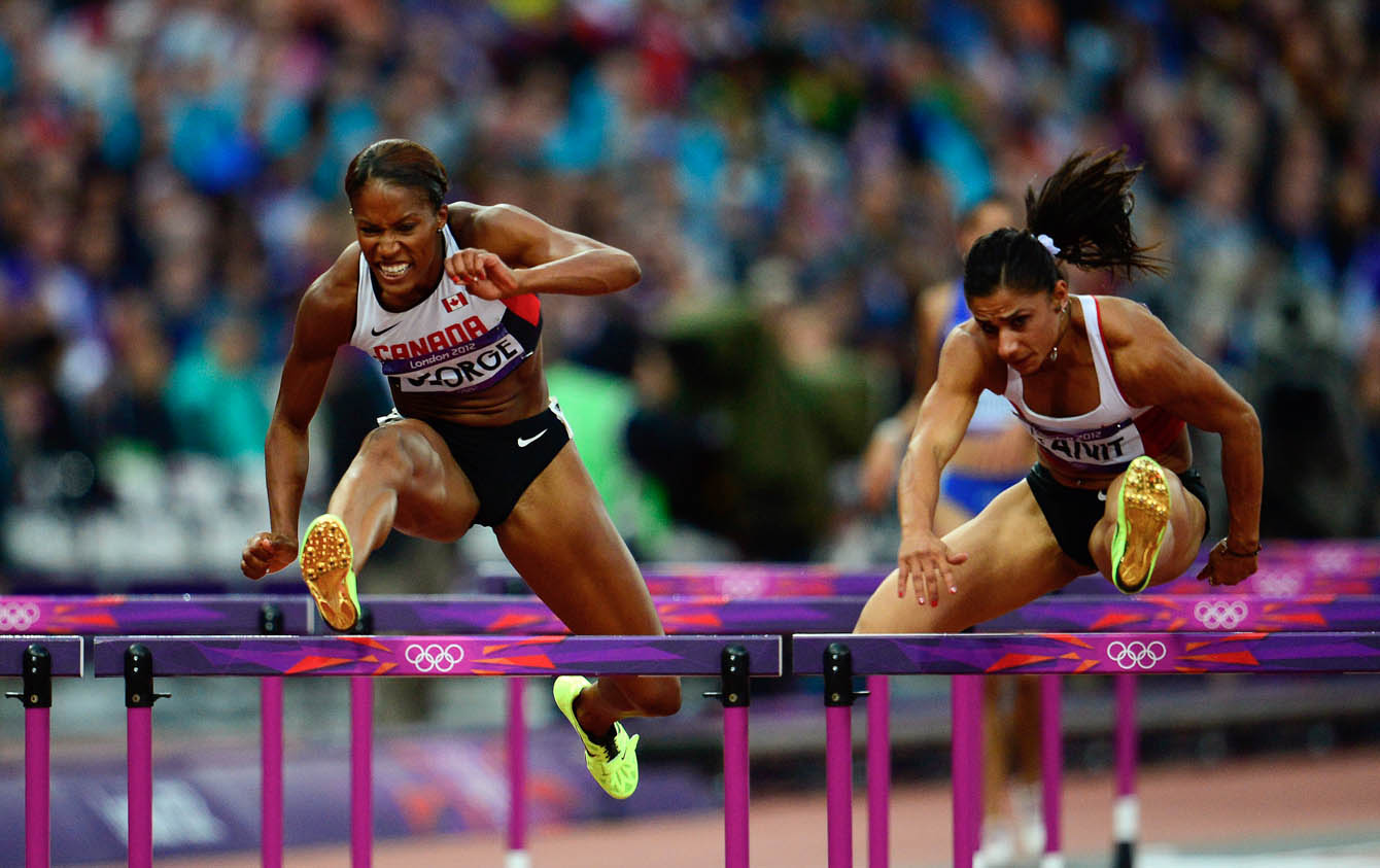 Canada's Phylicia George (left) competes in the women's 100-metre hurdle semifinals at the Olympic Stadium during London 2012 Olympics