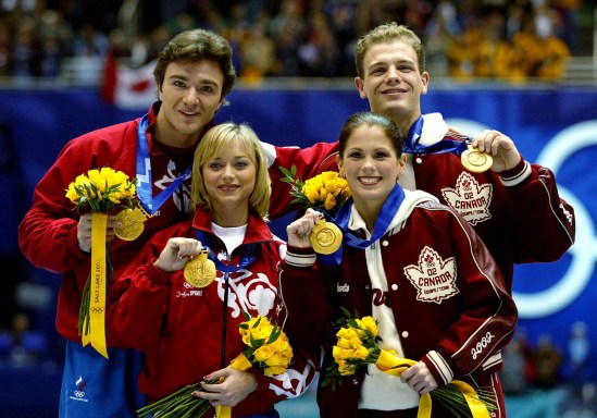 Gold medalists David Pelletier and Jamie Sale stand next to Russians Anton Sikharulidze and Elena Berezhnaya as they show off thier gold medals Sunday Feb. 17, at the 2002 Olympic Winter Games. (CP Photo/HO/COC/Andre Forget)