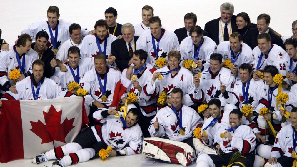 Team Canada captain Mario Lemieux and goalie Martin Brodeur are surrounded by teammates as they pose for a team photo after they won over Team USA to win the gold medal in hockey Sunday Feb. 24, 2002 at the 2002 Olympic Winter Games in Salt Lake City.