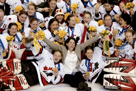 Canadian women's hockey team coach Daniele Sauvageau (centre) and the Canadian women's hockey team pose for a team picture with their gold medal after defeating the United States 3 - 2 in Salt Lake City , Utah during the Winter Olympics, Thursday, Feb. 21, 2002. (CP PHOTO/COC/Mike Ridewood)