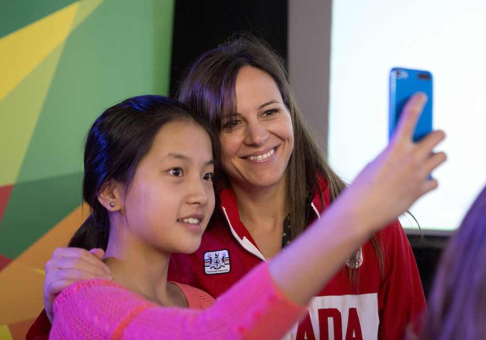 A fan takes a picture with a Team Canada athlete
