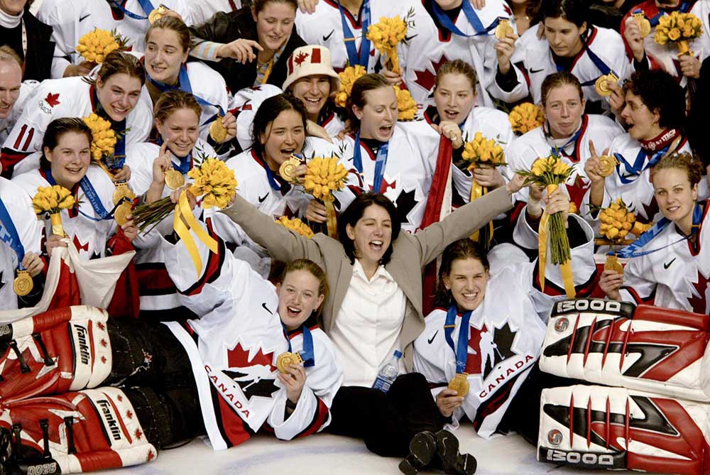 Team Canada women post on ice after winning gold 