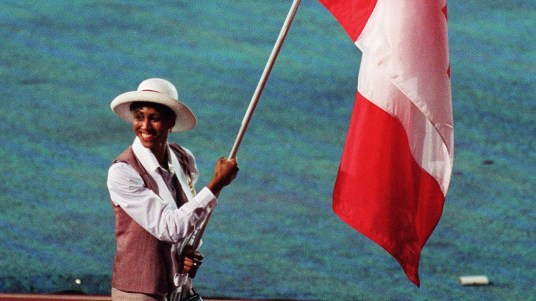 Charmaine Crooks bears the Canadian flag at the Atlanta 1996 Olympic Games Opening Ceremony. (CP Photo/COC)