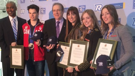 Toronto deputy mayor Norm Kelly (third from left) presents the Olympians with a scroll.