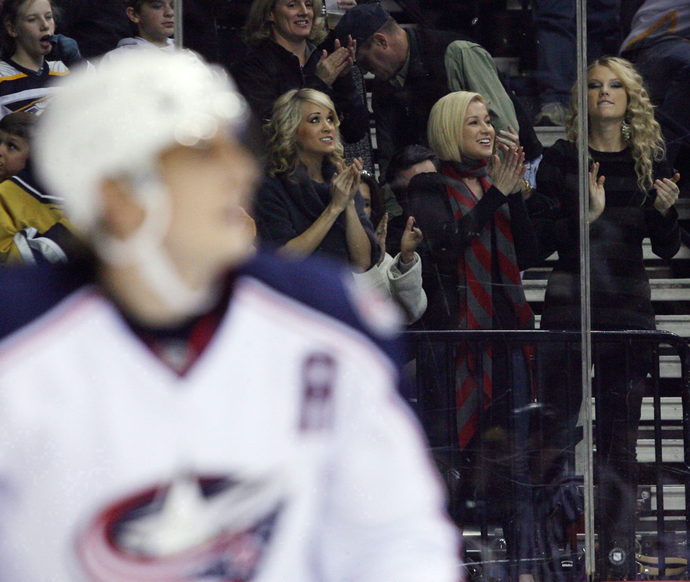 Country singers Underwood, left, Kellie Pickler, centre, and Taylor Swift cheering on the Predators. Photo: CP