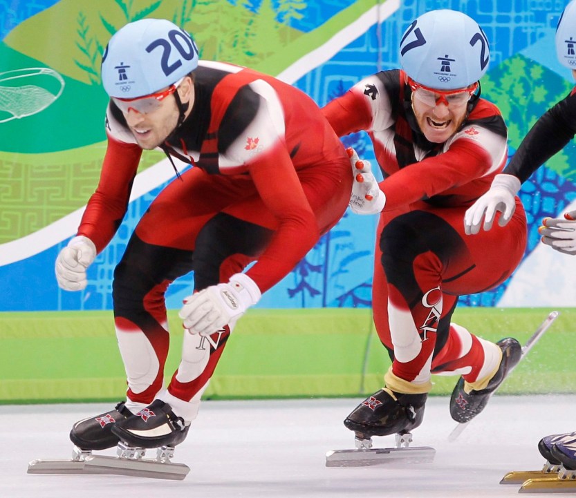 Canada's Olivier Jean, right, pushes teammate Francois-Louis Tremblay to go on to win the gold medal in the men's 5000 metre relay final in the short track speedskating competition Friday February 26, 2010 at the 2010 Vancouver Olympic Winter Games in Vancouver. THE CANADIAN PRESS/Paul Chiasson