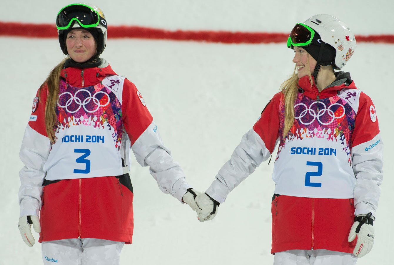 Olympic champion Justine Dufour-Lapointe, looks over at silver medallist sister Chloé before the women's moguls flower ceremony.