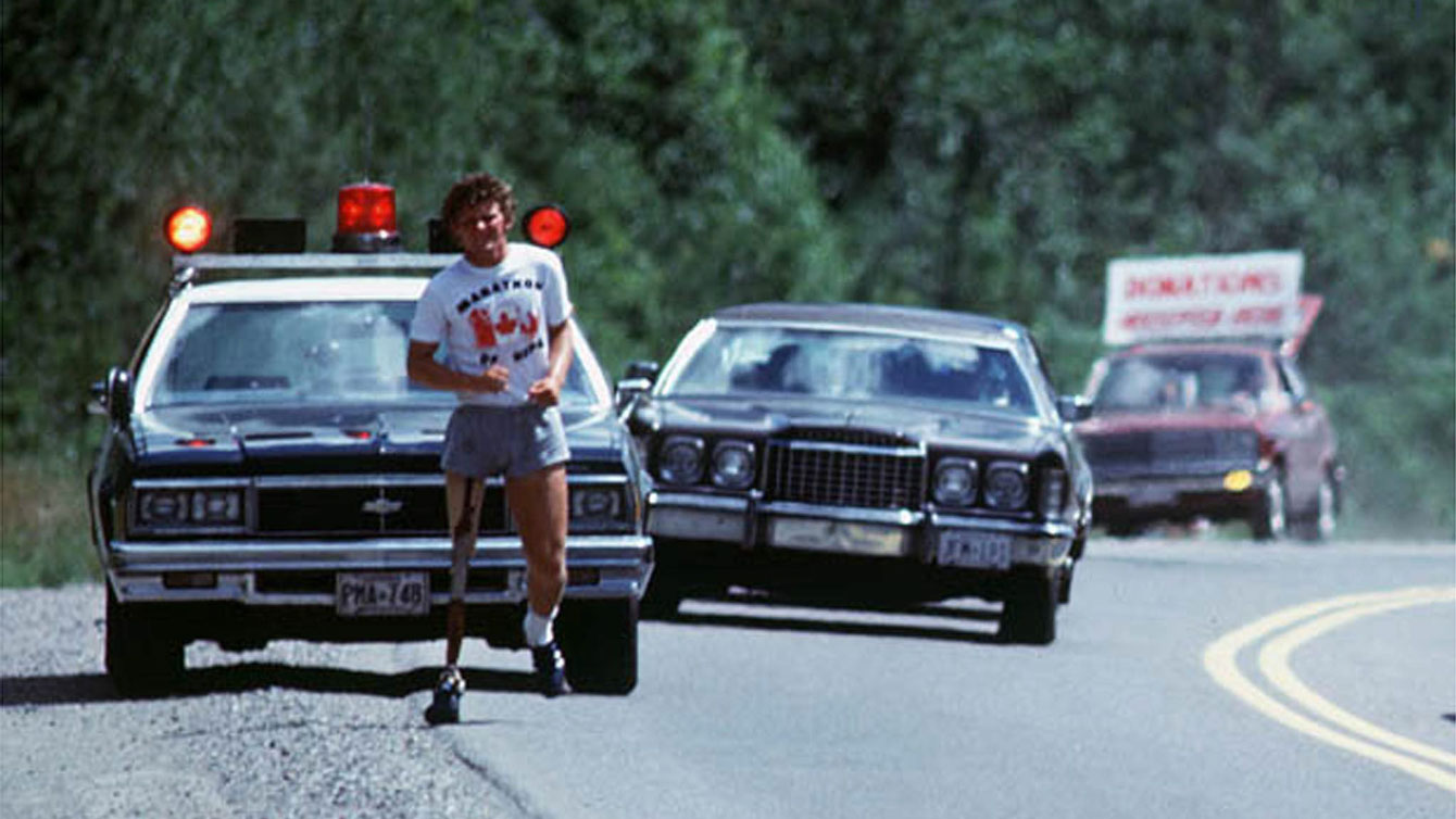 Terry Fox received Ontario Provincial Police escort while he ran through Ontario. In the photo, the third car in the convoy has a sign that reads "Donations Accepted Here."