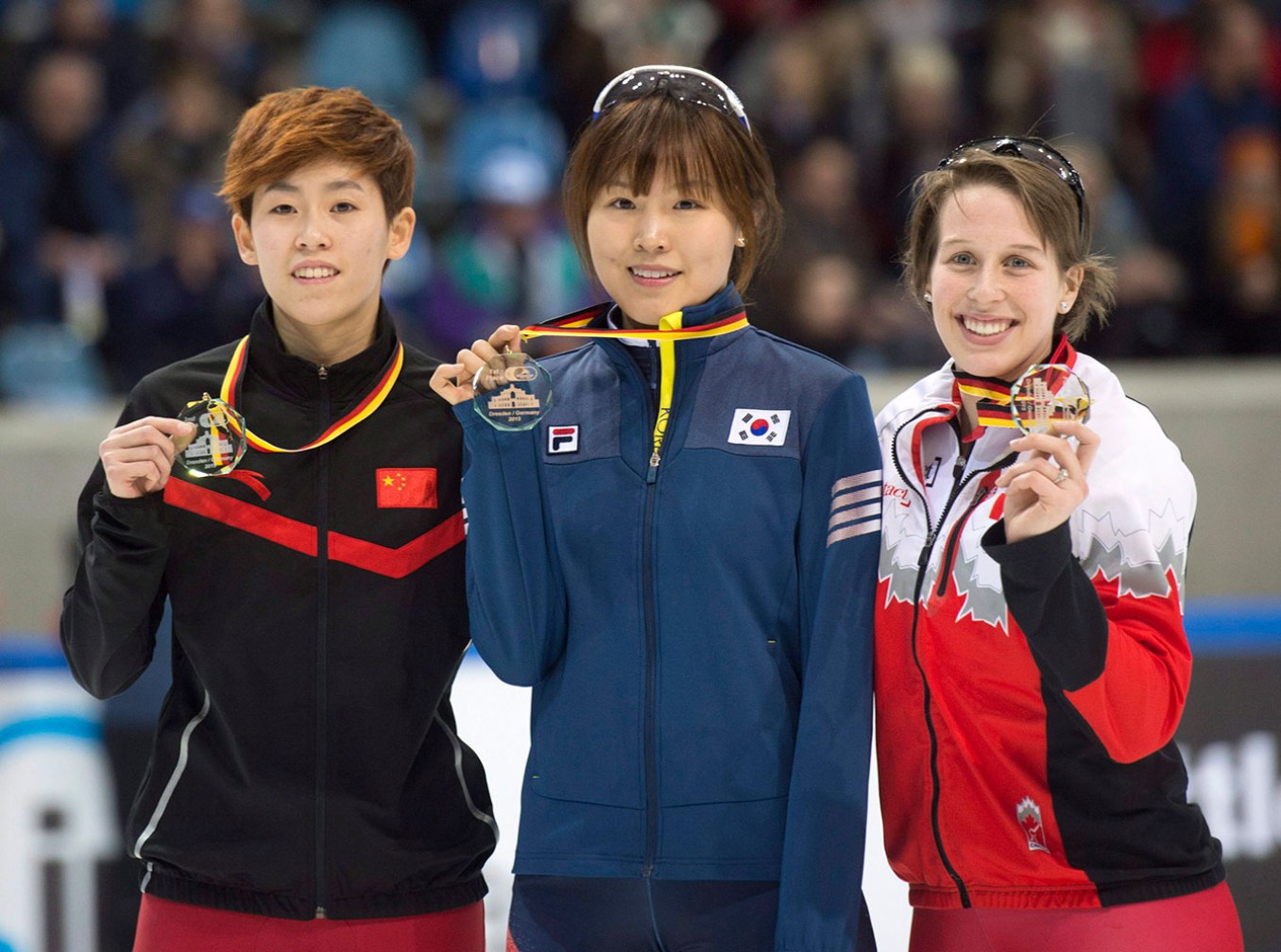 Winner Kim Alang of South Korea, center, celebrates with second placed Fan Kexin of China, left, and third placed Marianne St-Gelais of Canada during the medal ceremony after the women's 1,000 meter final race at the World Cup short track speed skating championship in Dresden, Germany, Saturday, Feb. 7, 2015. (AP Photo/Jens Meyer)