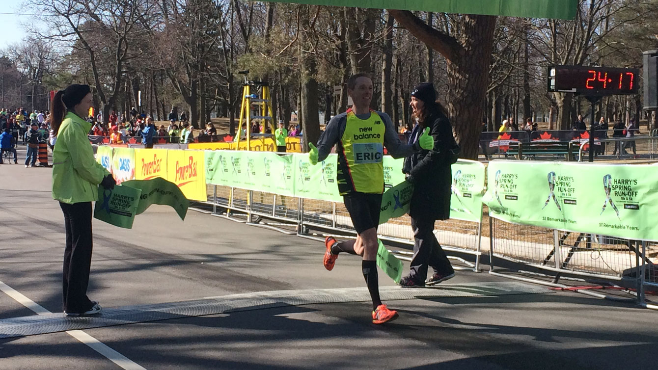 Olympian Eric Gillis breaks the tape to win the 2015 Canada Running Series Spring Run-Off at High Park. 