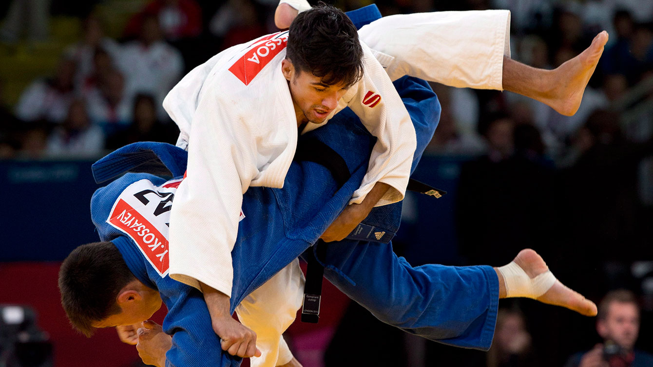 Canada's Sergio Pessoa fights with Kazakhstan's Yerkebulan Kossayev during their under 60kg preliminary round match at the 2012 Summer Olympics Saturday, July 28, 2012 in London.