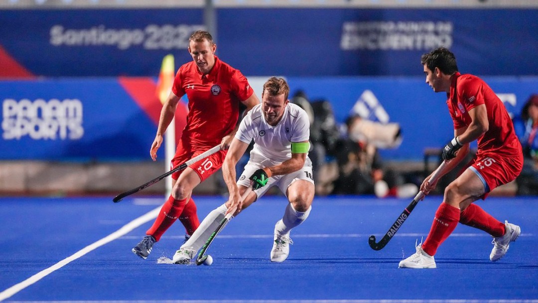 A group of field hockey players fight for the ball