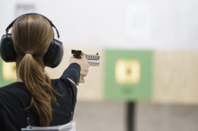 Athlete aiming pistol at target