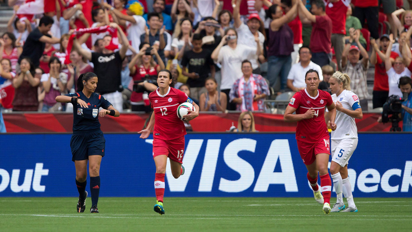 Christine Sinclair picks up the ball after scoring against England and gestures to the crowd to get behind Canada as it attempted to come back against England in a 2-1 FIFA Women's World Cup loss on June 27, 2015. 