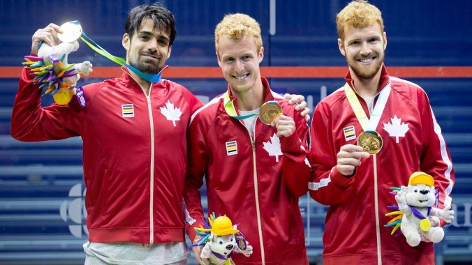 Canadian men's squash team, from left to right, Shawn Delierre, Andrew Schnell, and Graeme Schnell pose with their gold medal in men's team squash at the 2015 Pan Am Games.