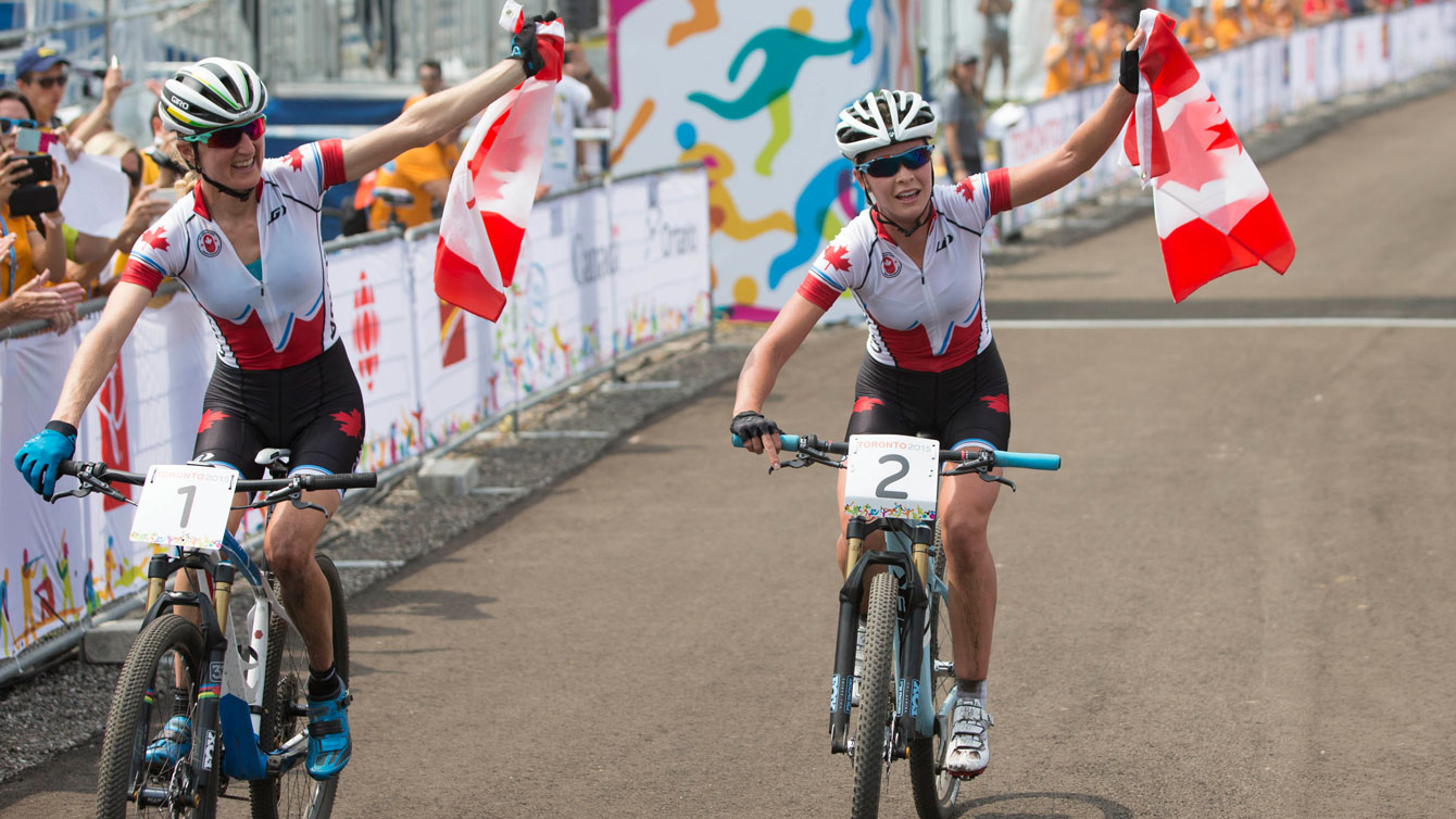 Emily Batty (right) and Catharine Pendrel raise the flag after finishing 1-2 at Pan Am mountain bike on July 12, 2015. 
