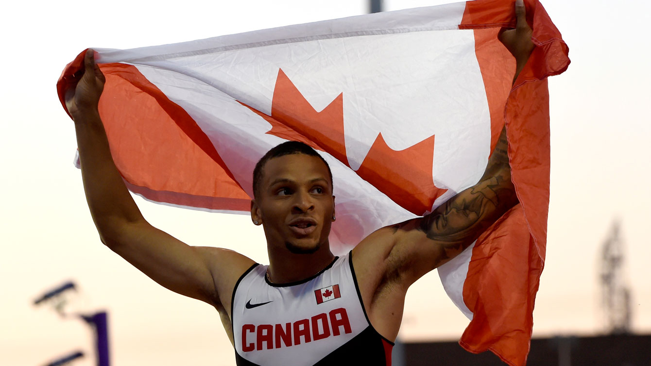 Andre De Grasse with the Canadian flag after winning the Pan Am Games 100m on July 22, 2015 in Toronto.