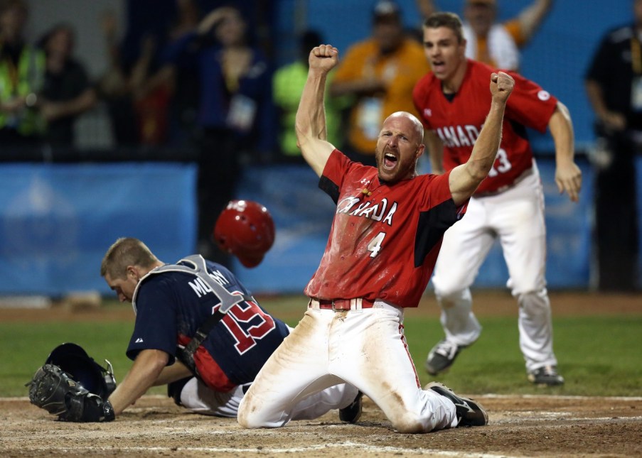 Peter Orr celebrates the extra inning gold medal-winning run over USA at the Pan Am Games men's baseball final (COC photo by Greg Kolz).