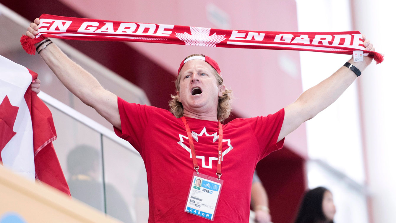 Curt Harnett holding a Team Canada scarf above his head