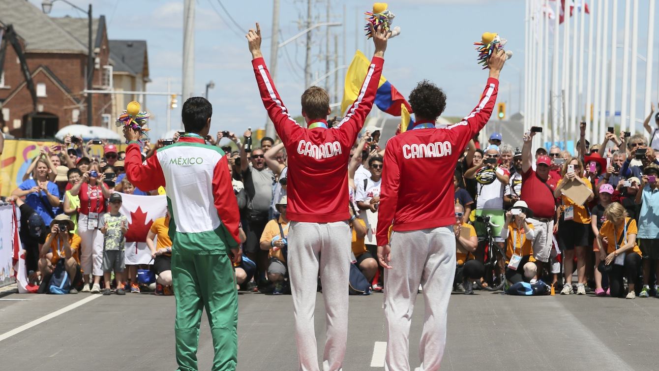 The medalists in the cycling time trial salute the crowd
