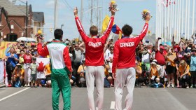 The medalists in the cycling time trial salute the crowd