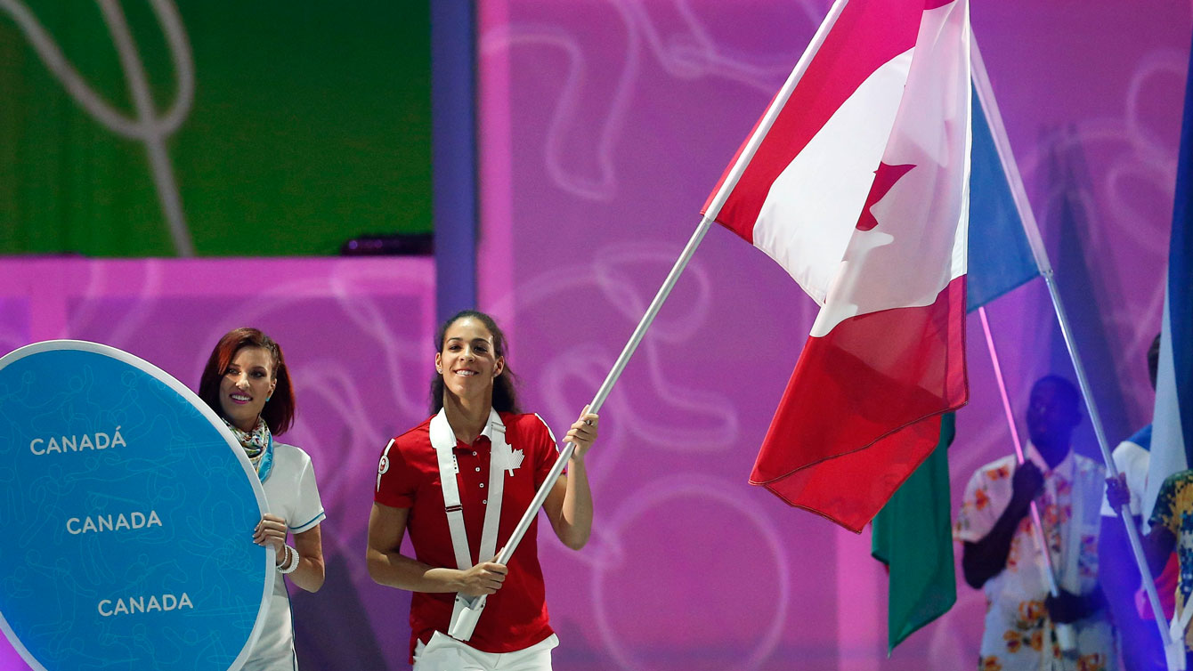 Kia Nurse proudly carries the flag during the TO2015 Closing Ceremony.