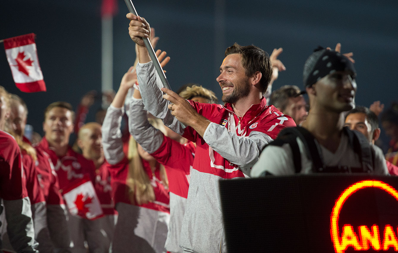 Mark Oldershaw carries the flag in for Canada at the Opening Ceremony for TO2015. The team in its Hudson's Bay kit.