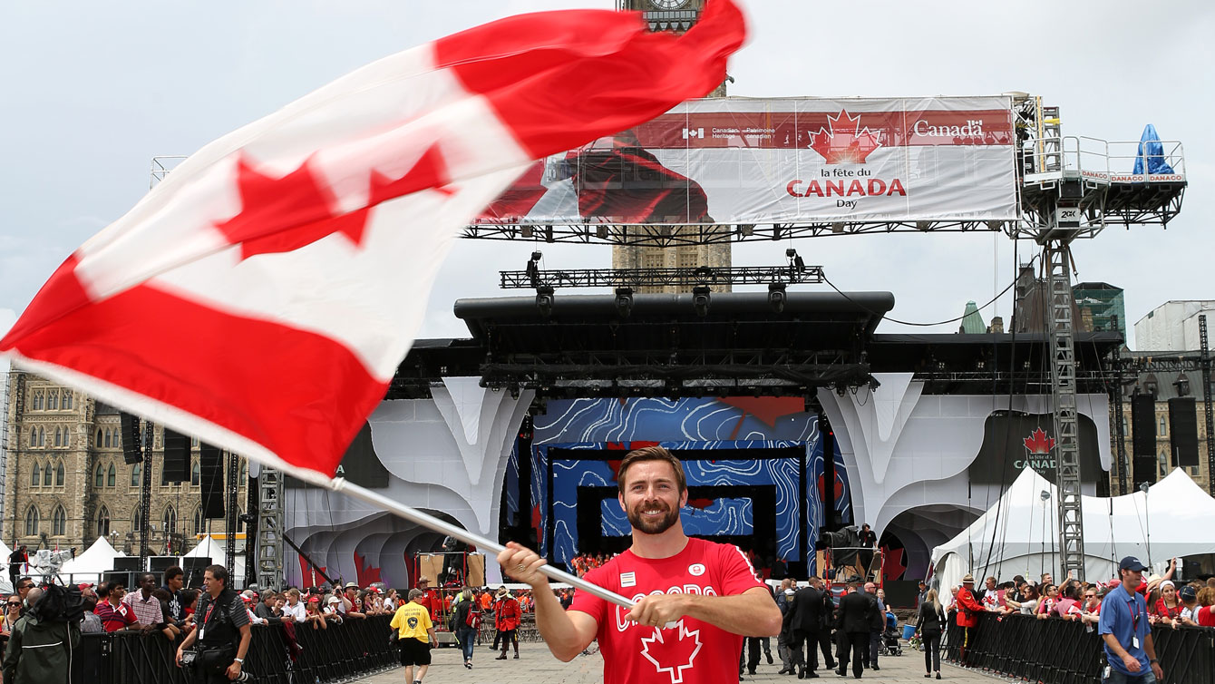 Mark Oldershaw waves the flag prior to Canada Day celebrations on Parliament Hill on July 1, 2015 (Greg Kolz for Canadian Olympic Team).