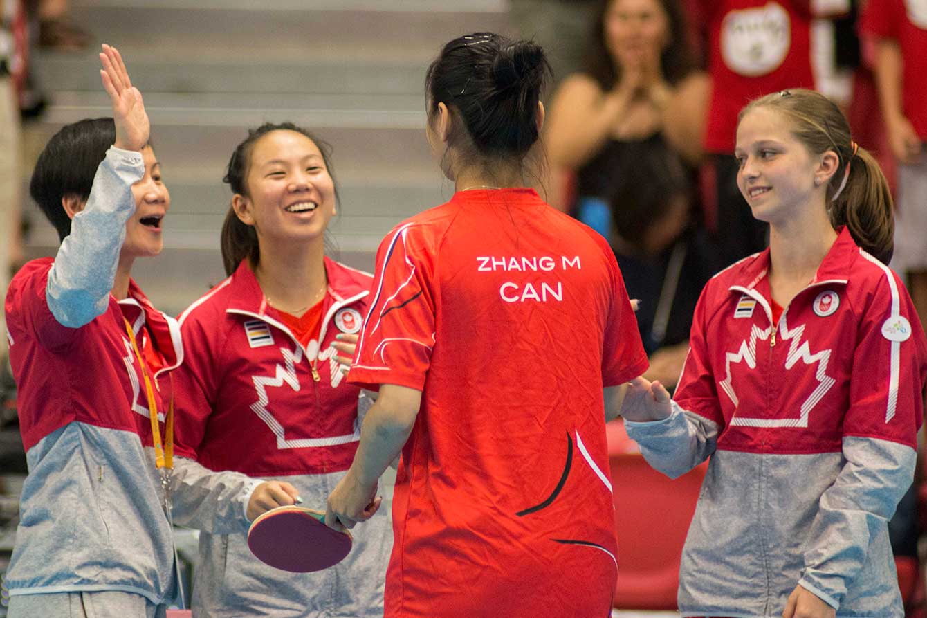Canadian coach Junya Chen (left to right), Anqi Luo, Mo Zhang, and Alicia Côté celebrate their TO2015 bronze medal.