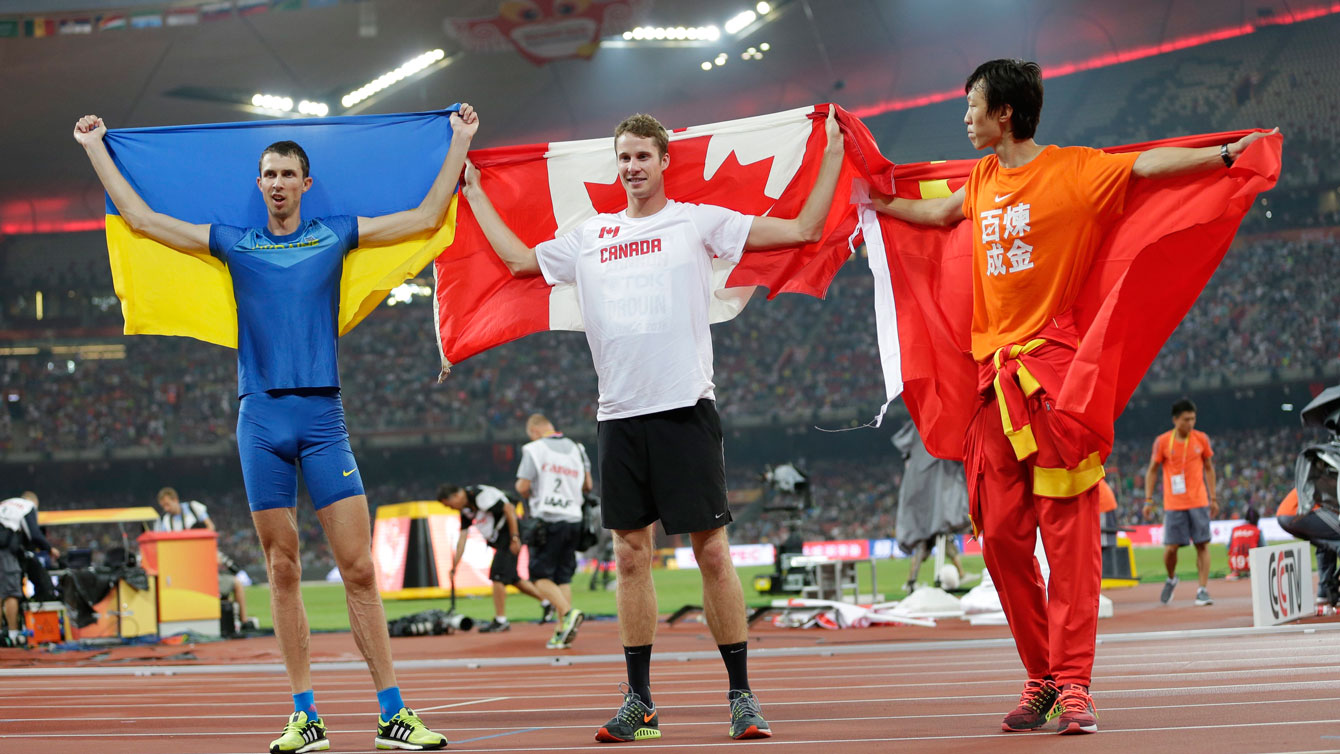 Derek Drouin (centre), stands with Bohdan Bondarenko (left), and Guowei Zhang at the conclusion of the high jump at the world championships in athletics on August 30, 2015 in Beijing, China. 