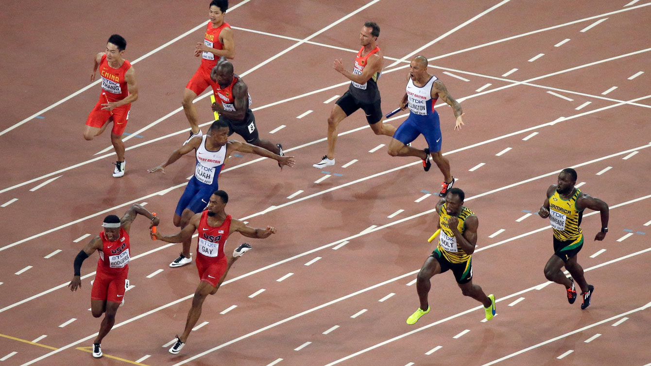 Mike Rodgers (bottom left, in red) receives the baton past the exchange zone from Tyson Gay of USA in the men's 4x100m final at the IAAF World Championships in Athletics on August 29, 2015.