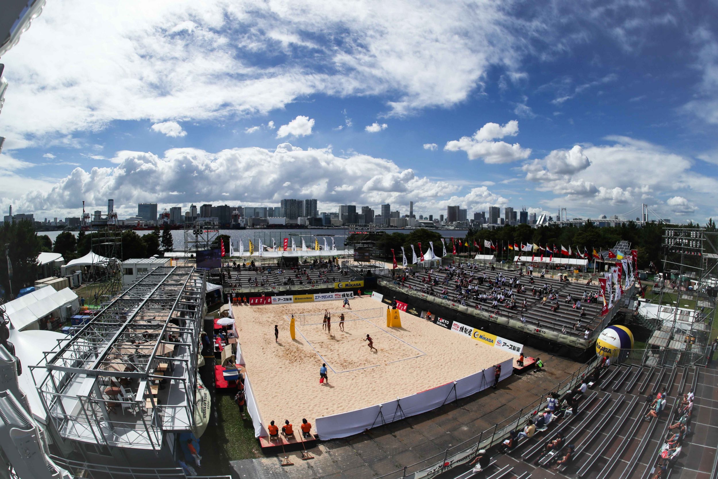 Players play beach volleyball at test event at Shiokaze Park